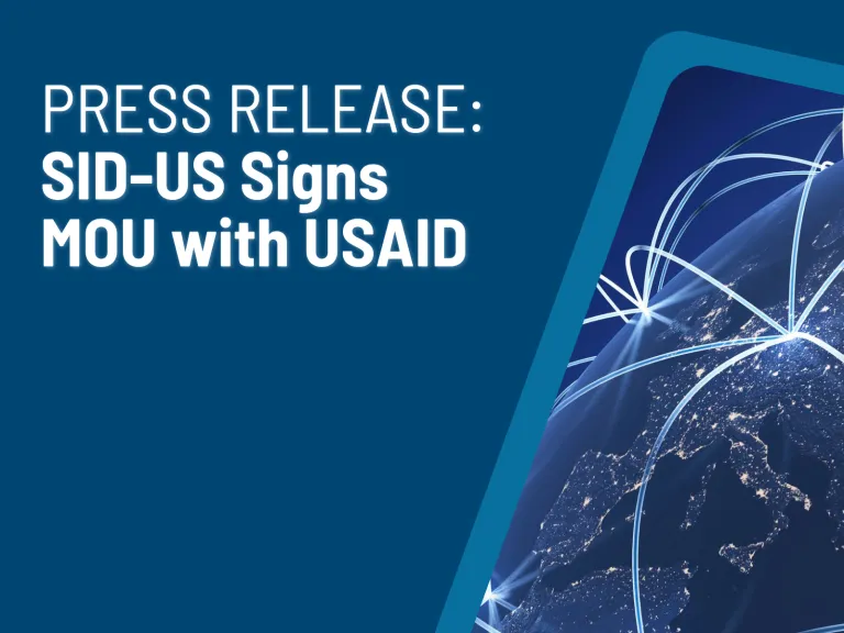 "PRESS RELEASE: SID-US Signs MOU with USAID" in white text over navy background. Graphic of beams of light connecting cities on a globe in righthand corner.