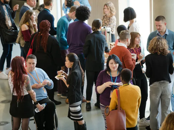 Attendees in a large hallway chatting during a conference