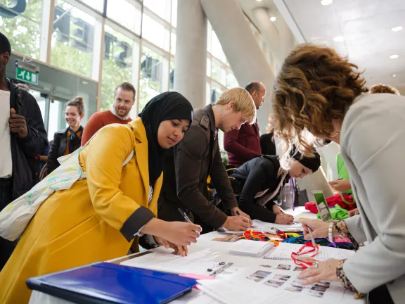 People leaning over registration table