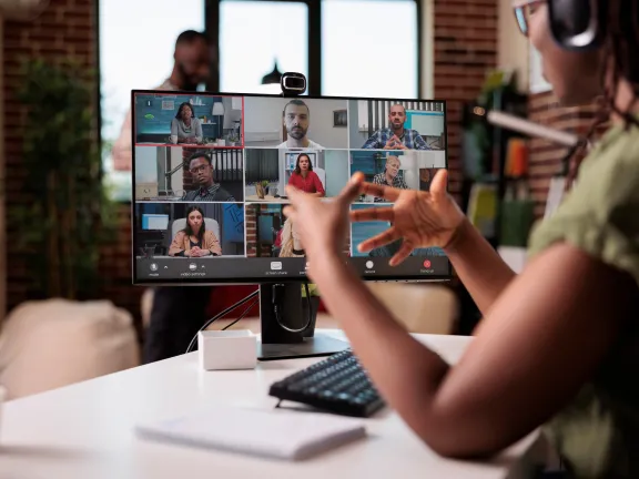 Woman participating in virtual call and gesturing at screen