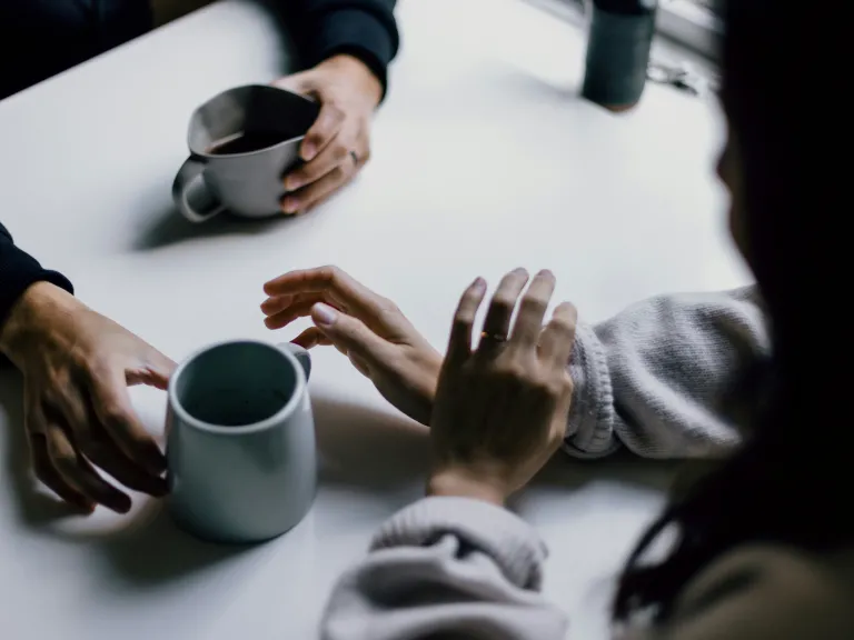Two people having coffee together while chatting